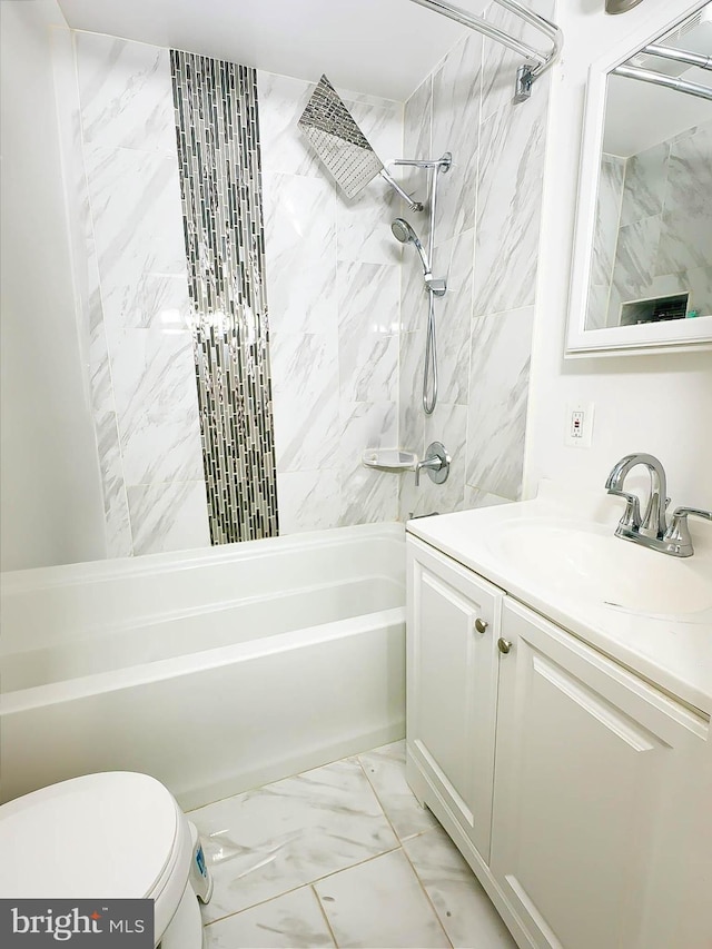 full bathroom with tiled shower / bath, vanity, and toilet