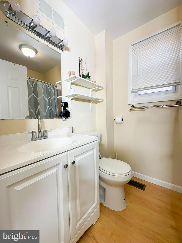 bathroom with vanity, toilet, and hardwood / wood-style floors