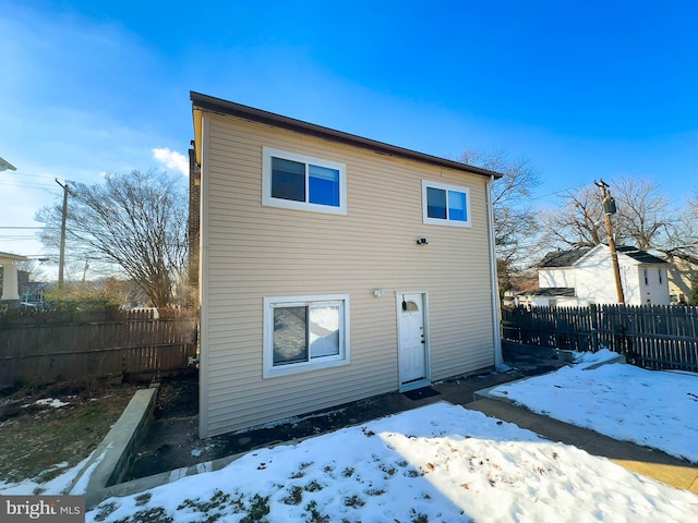 view of snow covered rear of property