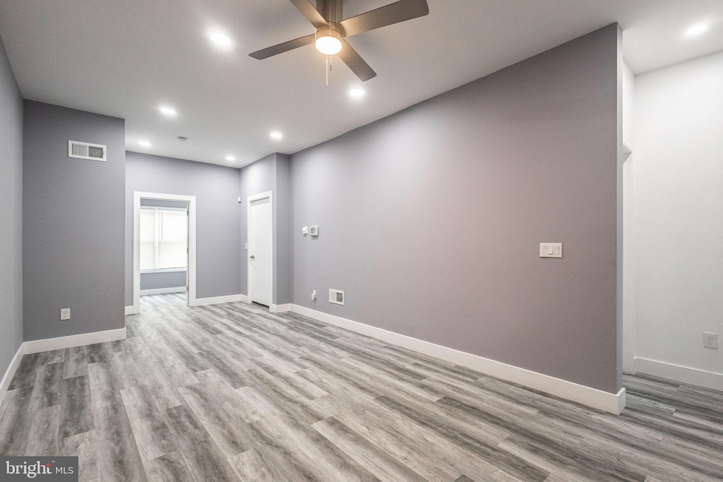 empty room with light wood-type flooring and ceiling fan