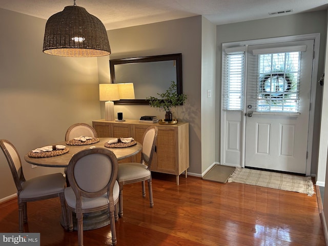 dining space with wood-type flooring