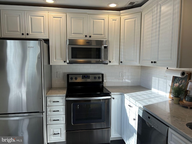 kitchen featuring white cabinetry, appliances with stainless steel finishes, backsplash, and light stone counters