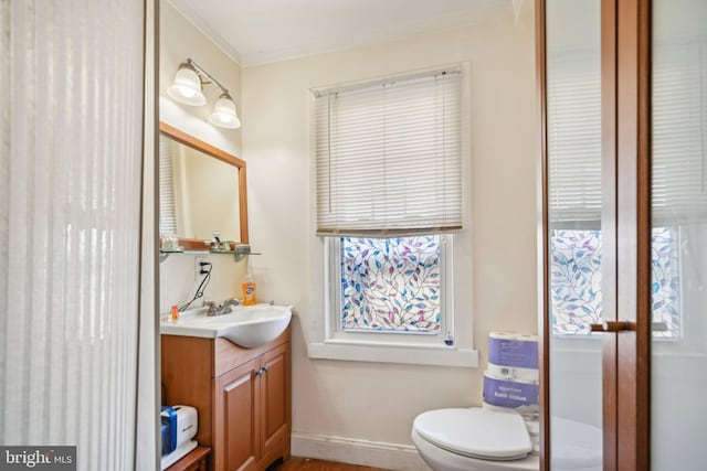 bathroom featuring ornamental molding, vanity, and toilet