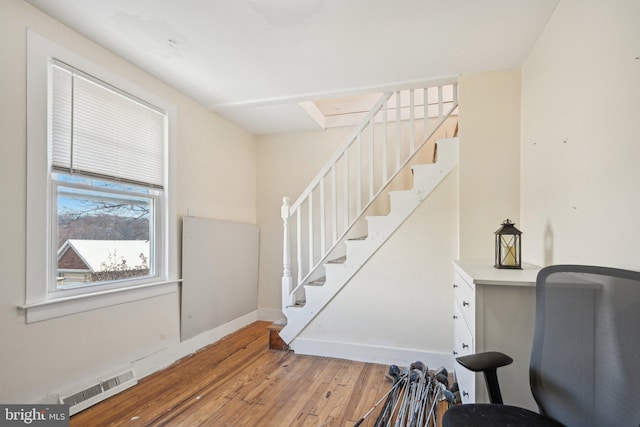 stairs featuring hardwood / wood-style floors