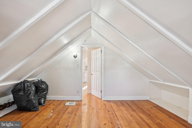 bonus room with hardwood / wood-style flooring and vaulted ceiling