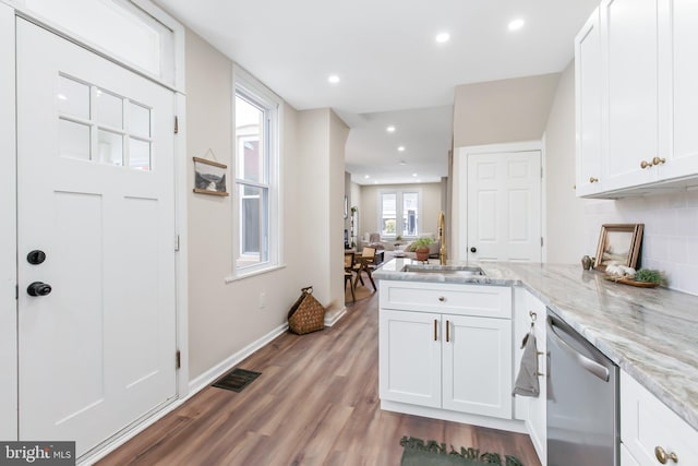 kitchen with white cabinetry, light stone countertops, kitchen peninsula, and dishwasher