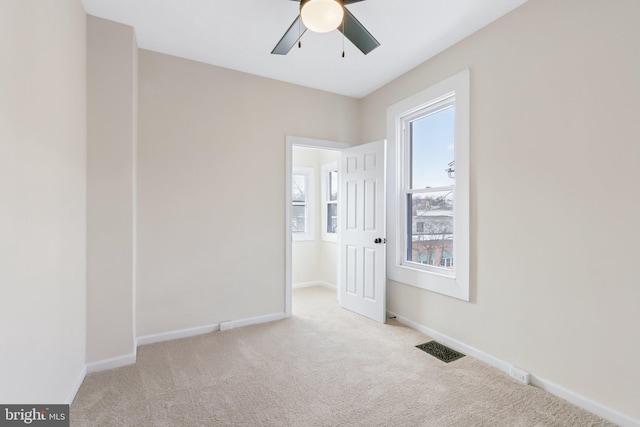 carpeted spare room with ceiling fan