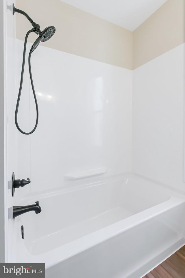 bathroom featuring hardwood / wood-style flooring and walk in shower