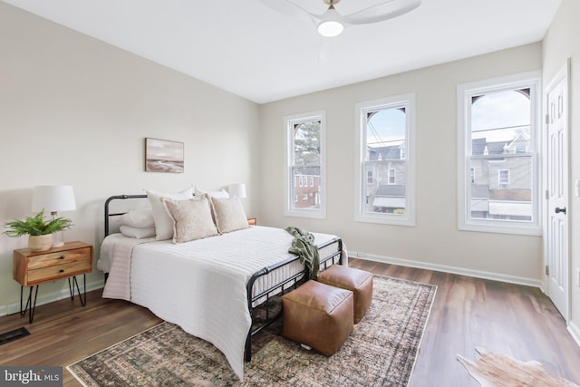 bedroom with dark hardwood / wood-style floors and ceiling fan