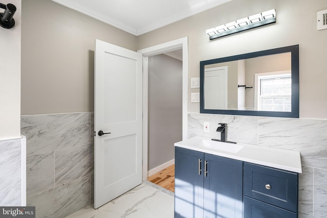 bathroom featuring vanity, crown molding, and tile walls