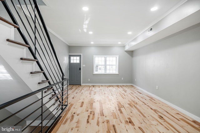 entryway featuring light wood-type flooring and ornamental molding