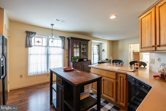 kitchen featuring dark wood-type flooring, sink, tasteful backsplash, pendant lighting, and black appliances