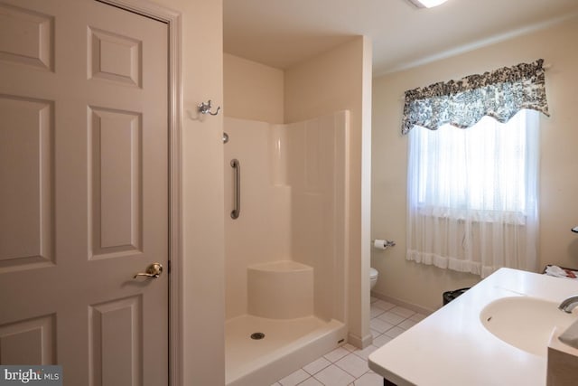 bathroom featuring a shower, vanity, tile patterned floors, and toilet