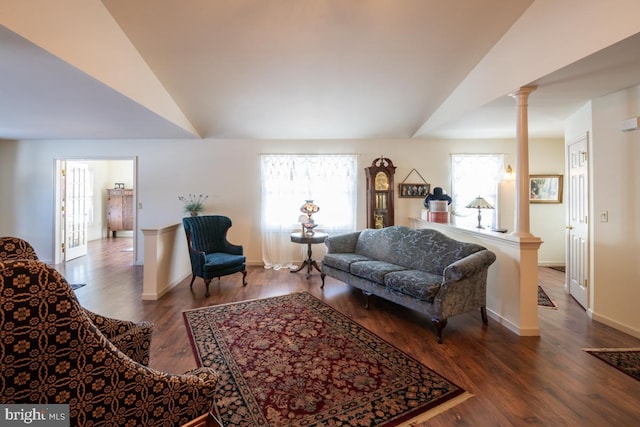 living room featuring lofted ceiling, hardwood / wood-style floors, and ornate columns