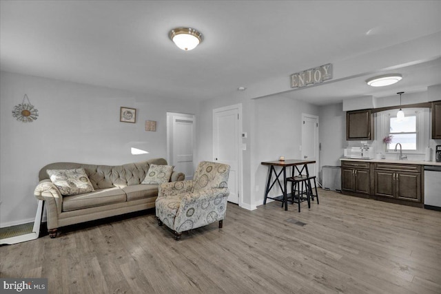 living room featuring sink and light hardwood / wood-style flooring