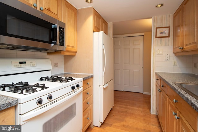 kitchen featuring decorative backsplash, white appliances, sink, and light hardwood / wood-style flooring