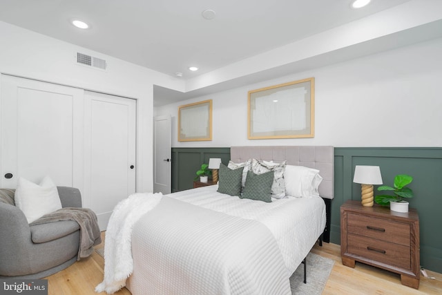 bedroom with light wood-type flooring and a closet