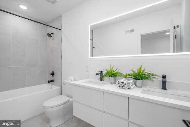 full bathroom featuring toilet, tiled shower / bath, tile patterned floors, and vanity