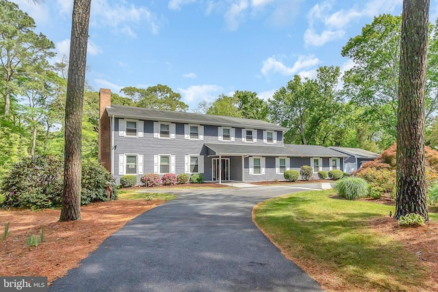 colonial-style house featuring a front lawn