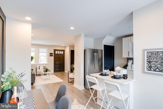 kitchen featuring white cabinets, high end refrigerator, and light hardwood / wood-style floors