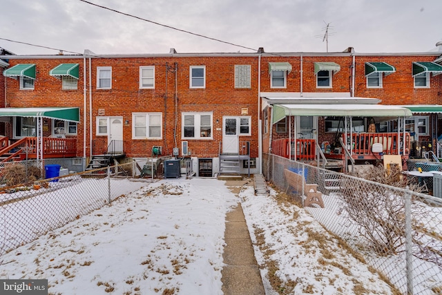 snow covered property featuring central AC