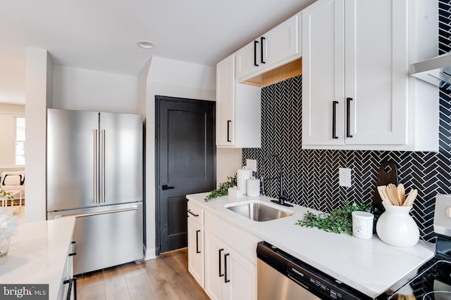 kitchen with white cabinets, stainless steel appliances, tasteful backsplash, and sink