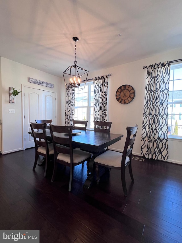 dining room with a notable chandelier and dark wood-type flooring