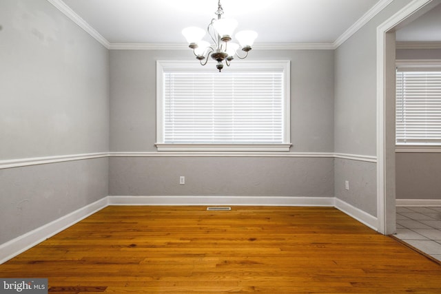 empty room with ornamental molding, a chandelier, and tile patterned flooring