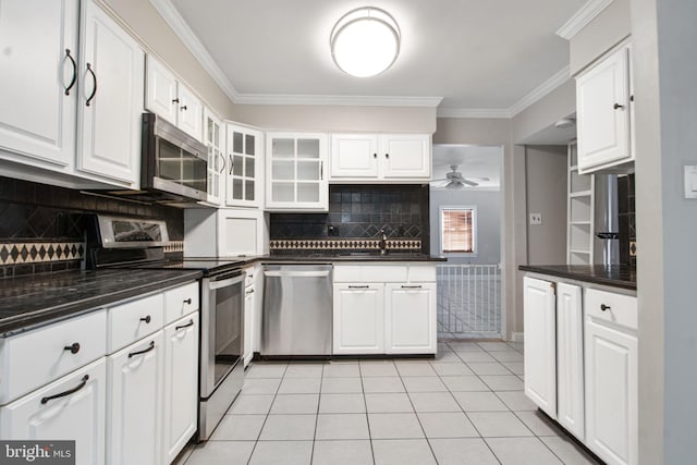 kitchen featuring crown molding, appliances with stainless steel finishes, light tile patterned floors, and white cabinets