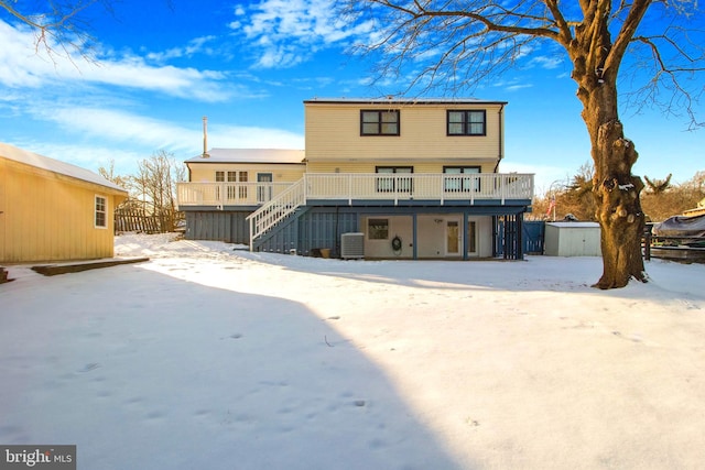 snow covered house featuring a deck and central air condition unit