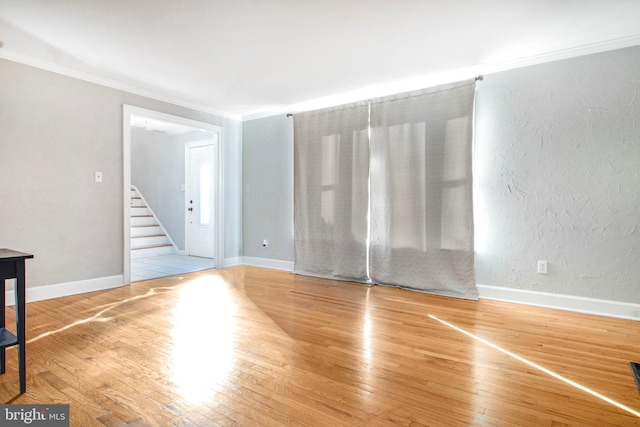 unfurnished room with hardwood / wood-style floors and crown molding