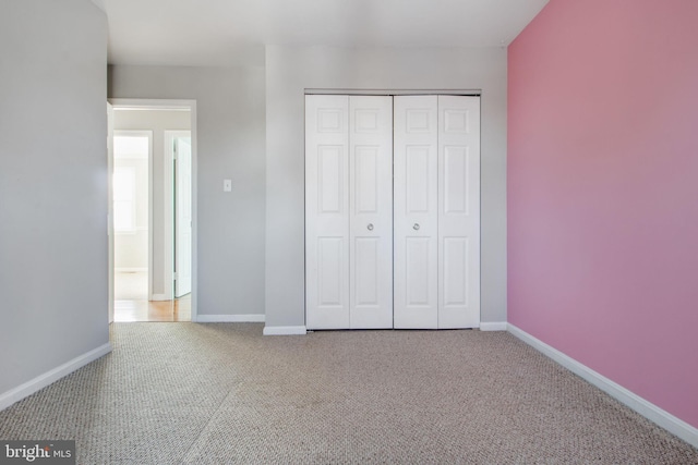 unfurnished bedroom featuring carpet floors and a closet