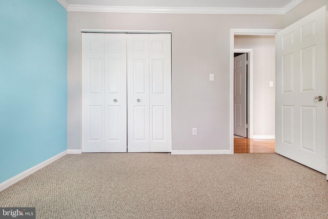 unfurnished bedroom with ornamental molding, carpet, and a closet