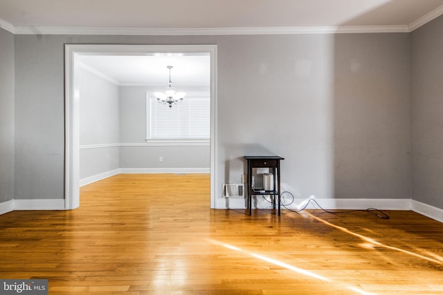 empty room featuring an inviting chandelier, ornamental molding, and wood-type flooring