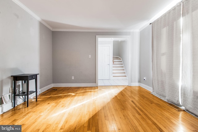 unfurnished living room featuring light hardwood / wood-style flooring and ornamental molding