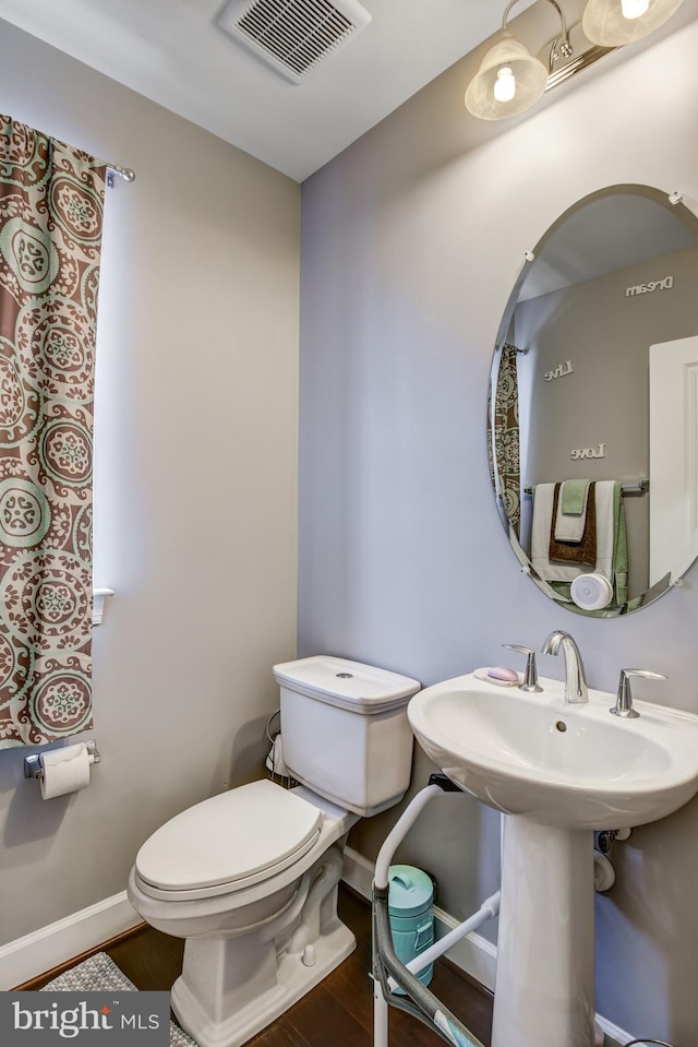 bathroom with hardwood / wood-style flooring and toilet