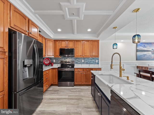 kitchen with light stone countertops, stainless steel appliances, sink, hanging light fixtures, and light wood-type flooring