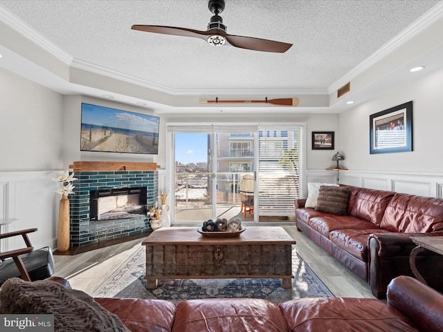 living room with crown molding, a textured ceiling, and a tray ceiling