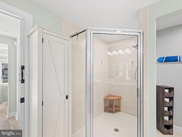 bathroom featuring a shower with door and wood-type flooring