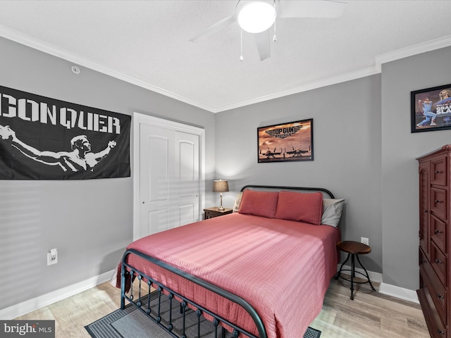 bedroom featuring light wood-type flooring, ceiling fan, crown molding, and a closet