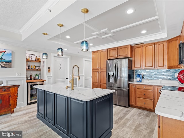 kitchen featuring light stone countertops, hanging light fixtures, a kitchen island with sink, stainless steel refrigerator with ice dispenser, and beverage cooler