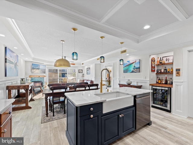 kitchen featuring dishwasher, sink, decorative light fixtures, an island with sink, and wine cooler