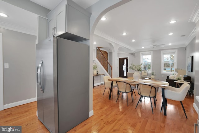 dining area with crown molding, ceiling fan, and light hardwood / wood-style flooring