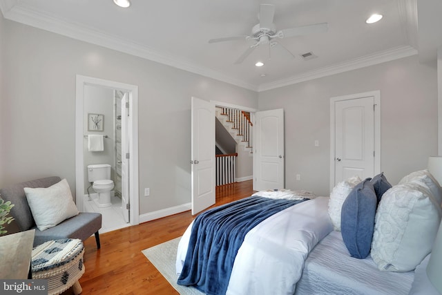 bedroom featuring ceiling fan, ornamental molding, wood-type flooring, and ensuite bath