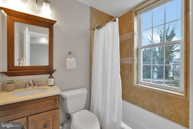 full bathroom featuring vanity, a wealth of natural light, toilet, and shower / bath combo with shower curtain