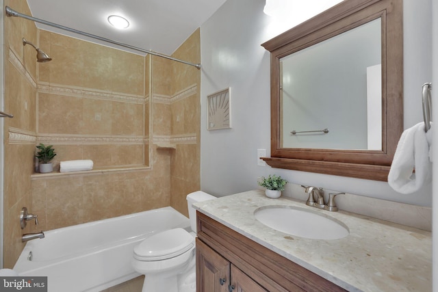 full bathroom with tiled shower / bath, vanity, and toilet