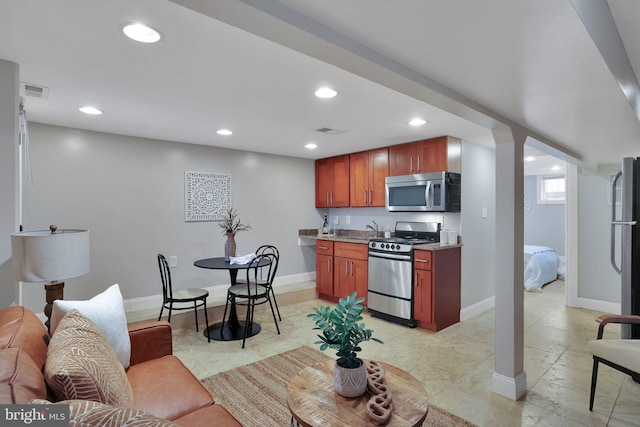 kitchen with light stone counters, stainless steel appliances, and sink