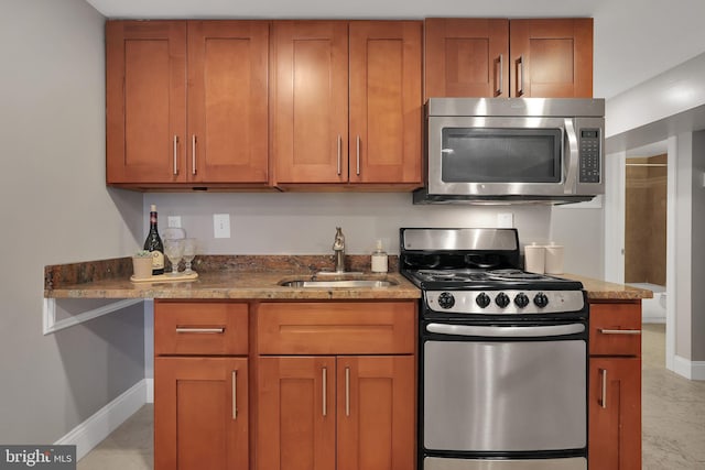 kitchen featuring appliances with stainless steel finishes, sink, and dark stone counters