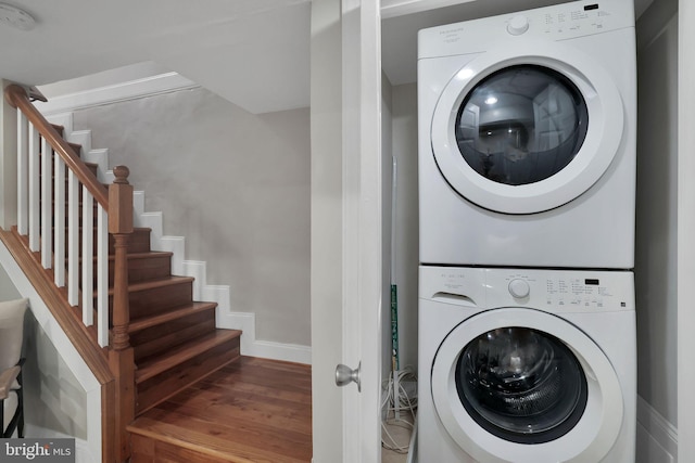 clothes washing area featuring stacked washer and dryer and hardwood / wood-style floors