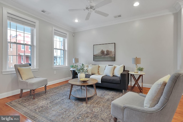 living room with wood-type flooring, ornamental molding, and ceiling fan